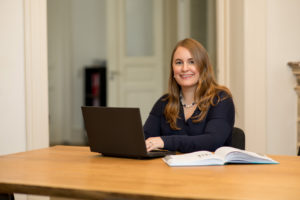 Für ein Führungskräftetraining arbeitet Marietta Gädeke mit Computer und Sachbüchern